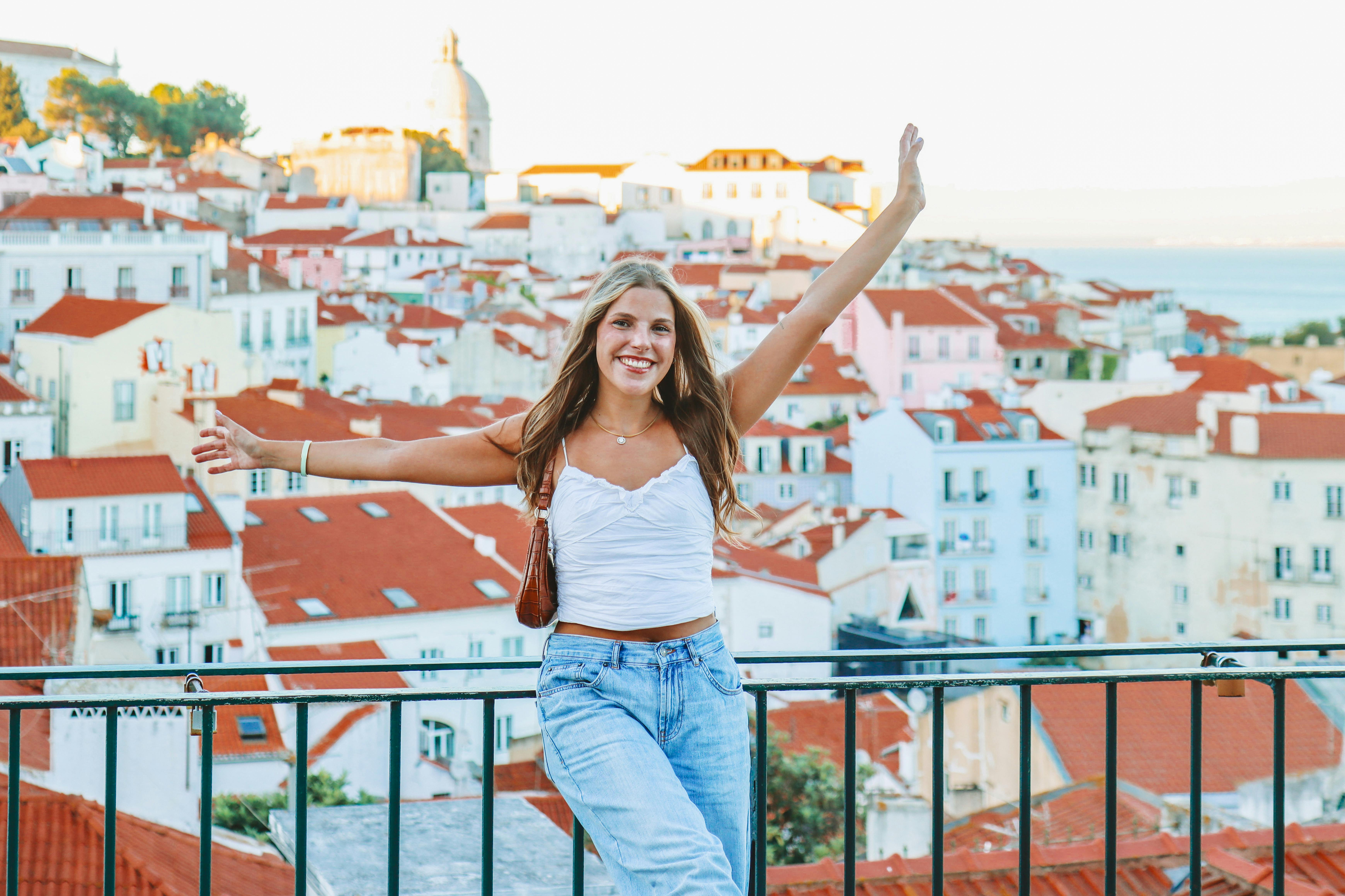 girl standing on a viewpoint in front of many houses smilling and raising her ams in front of the sentence job opportunities without experience